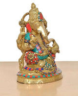 Brass Lord Ganesha idol angled view with gold body, red teal accents, and jeweled belt.