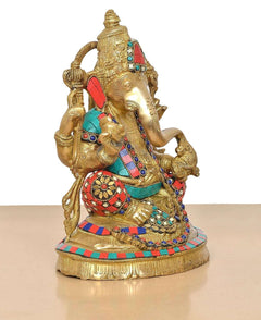 Brass Lord Ganesha idol angled view with gold body, red teal accents, and jeweled belt.