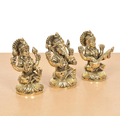 Brass Lakshmi Ganesha Saraswati idol set, angled view of three golden deities