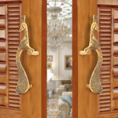 Brass peacock design door handle pair on a wooden door, golden finish