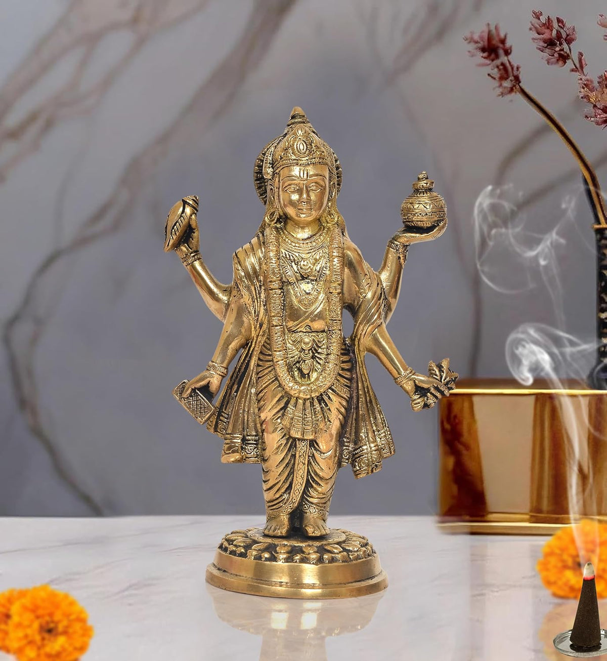 Brass Dhanvantri deity statue with raised arms, ornate jewelry, standing on round base