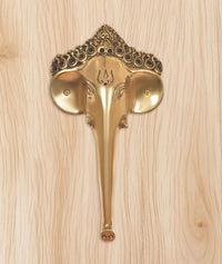 Golden brass Ganesha face door handle with engraved head and fan-like side plates