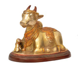Brass Nandi bull showpiece statue, side view, seated posture with decorative robe