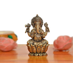 Lord Ganesha bronze idol, four arms, seated on detailed pedestal