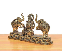 Side view brass Lakshmi statue with two standing elephants and ornate pedestal base