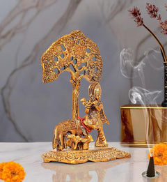 Metal Krishna and cow idol statue, long tree trunk with ornate canopy cutouts
