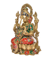 Brass Ganesha idol in profile, red skirt, green-blue patterns, decorative arms and halo