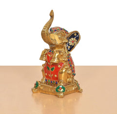 Brass elephant figurine, seated pose with raised trunk; multicolor painted details