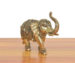 Brass elephant figurine, three-quarter view with patterned body and raised trunk