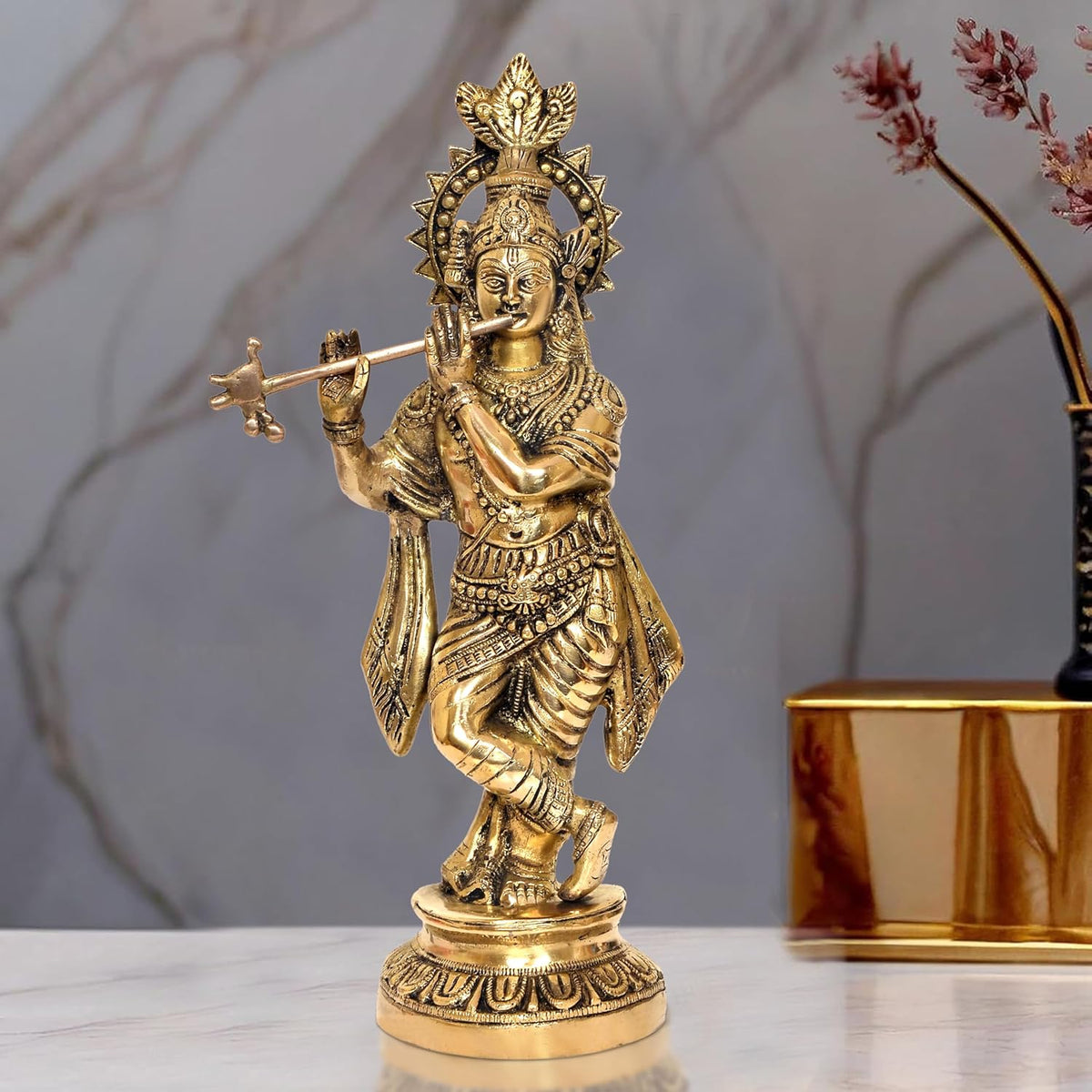 Brass Lord Krishna idol playing flute with ornate crown, standing on round base