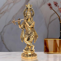 Brass Lord Krishna idol playing flute with ornate crown, standing on round base