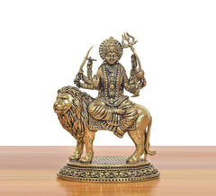 Brass Durga Maa statue riding a lion, ornate crown, necklaces, and trident-like arms