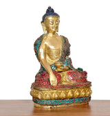 Messing-Buddha im Meditationssitz, Blick von vorn-seitig, türkis/rot gestickte Robe