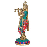 Brass Krishna statue holding flute with marigold beads, teal and red patterned robe