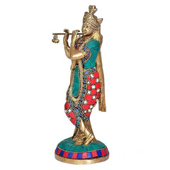 Brass Krishna statue holding flute with marigold beads, teal and red patterned robe