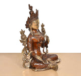 Dreiviertelansicht: sitzende Tara-Devi Messingstatue mit gefalteten Händen und ornamentierter Robe