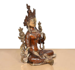 Dreiviertelansicht: sitzende Tara-Devi Messingstatue mit gefalteten Händen und ornamentierter Robe