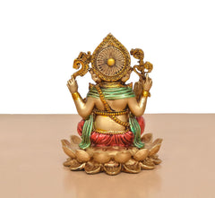 Back view: Ganesh resin statue seated on lotus, green and red garments, gold halo