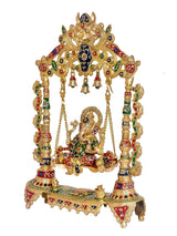 Ornate brass Ganesha swing, multicolor pillars with hanging bells and swing seat