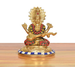 Side view multicolor brass Ganesh idol seated on circular blue-striped base
