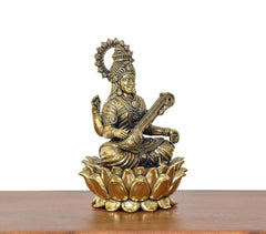 Brass Maa Saraswati statue angled view, detailed jewelry and lotus petals base