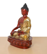 Side view Buddha statue: red body, gold robe, one hand holding a bowl, carved pedestal base