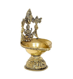 Brass oil lamp diya featuring seated Lakshmi at center with attendants on raised arms