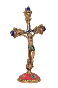 Angled view brass Jesus cross with blue medallions, green accents, red base