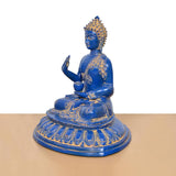 Blue brass Buddha statue in profile, seated meditation pose with gold accents