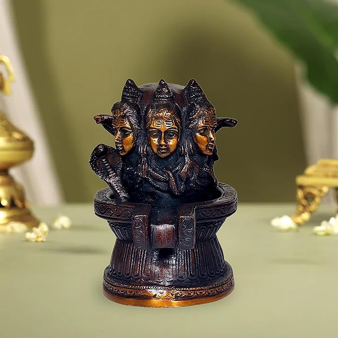 Brass Shiva linga statue with three engraved heads, front view on pedestal