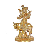 Brass khaniya statue: cow with flute-playing figure, side view on round base