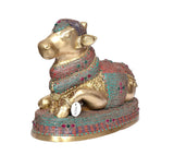 Side view of brass Nandi bull statue with colorful embroidered-looking panels