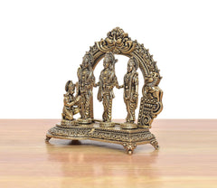 Brass ram darbar statue, side view, carved arch frame with three standing deities