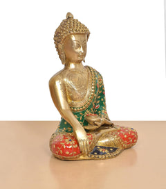 Brass Buddha statue three-quarter view, green robe with red patterned skirt