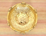 Top view of brass urli with engraved patterns, central oval design, elephant finials