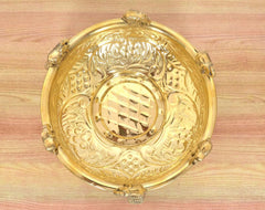 Top view of brass urli with engraved patterns, central oval design, elephant finials