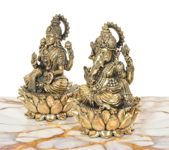 Side view brass Lakshmi and Ganesh statues on lotus bases, raised hands and crowns