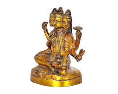 Brass Dattatreya sitting statue with four-faced head and ornate jewelry, 4.5 in