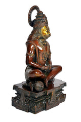 Bronze-toned Hanuman yoga pose idol statue side profile, seated cross-legged on ornate base
