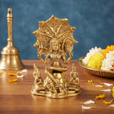 Brass Dakshinamurti Shiva statue with ornate halo and small seated devotees on base