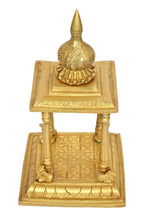 Brass pooja mandir detail: finial, paneled sides, and tiled base on open stand