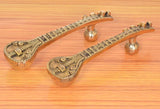 Brass sitar-shaped door handle pair with textured stems and ornate base plates
