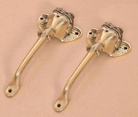 Golden brass Ganesha face door handles, angled view showing curved levers