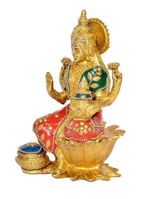 Lakshmi brass statue side view, green patterned outfit, holding pot on lotus