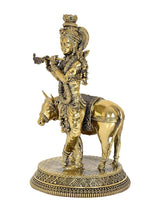 Brass Krishna riding cow statue, side view, flute gesture and detailed ornaments