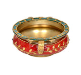 Brass urli with red base, gold interior, blue beaded border, and central support piece