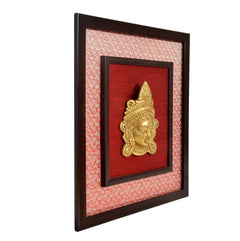 Brass Maa Durga face idol wall hanging side view, dark frame with gold relief inside