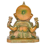 Back view of brass Ganesha idol, seated with decorative back and raised arms