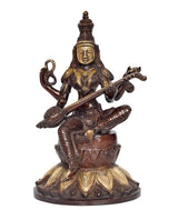 AONA Saraswati idol seated on lotus with veena, dark patina and gold accents.