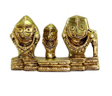 Gold-finish decorative idol: three stylized faces on shared pedestal, detailed engravings